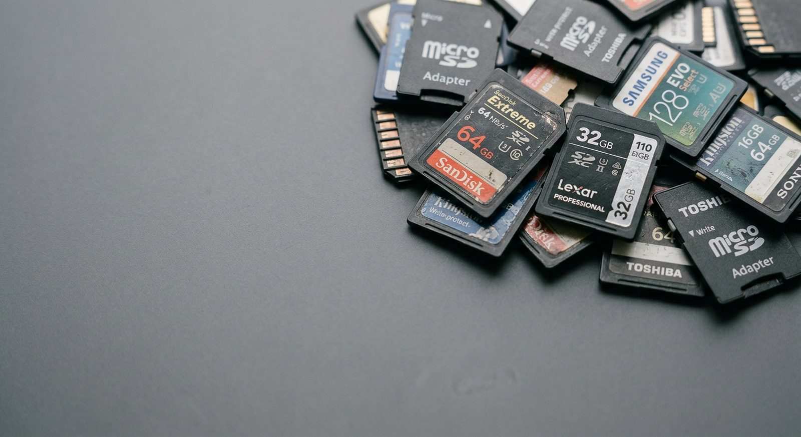 A pile of used SD memory cards on a gray desk